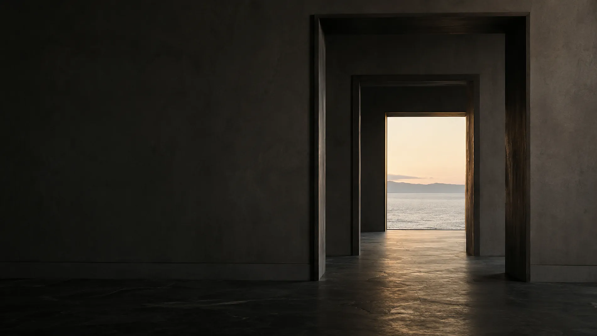 A sequence of deep architectural openings receding toward a pale dawn sky over calm water.